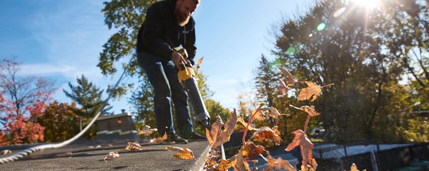 Installer carrying gutter stock toward a residential project